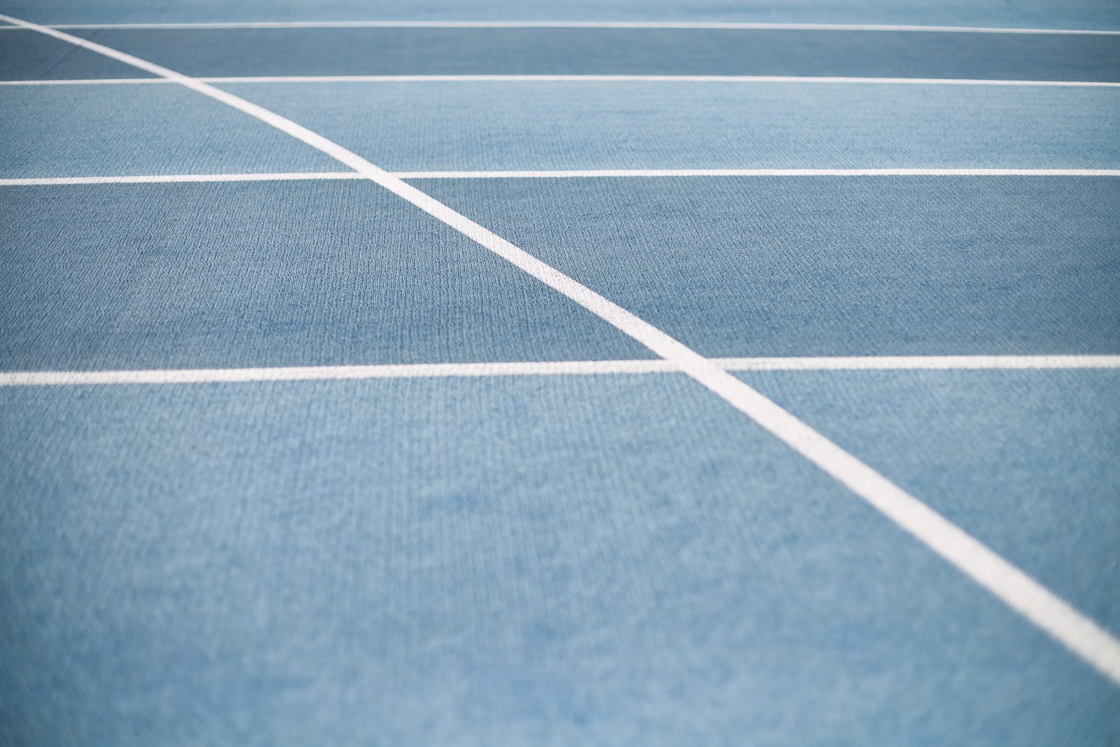 a blue tennis court with white lines on it